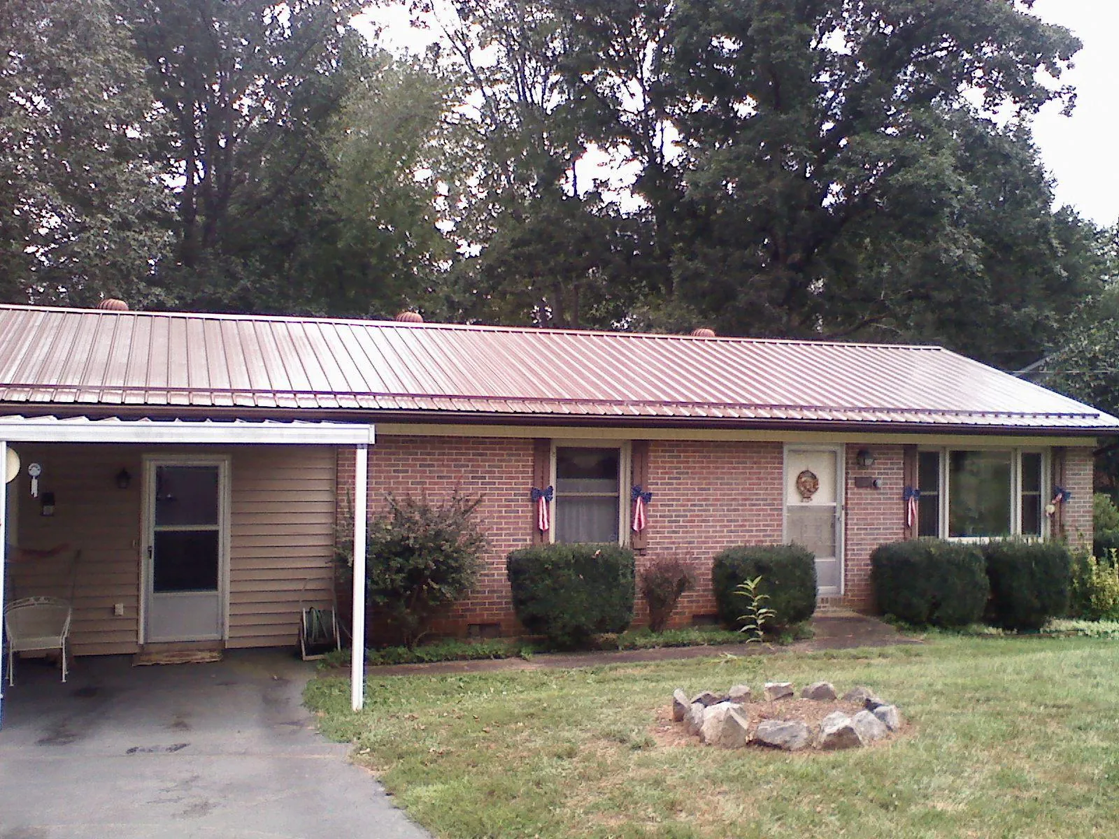 Bronze metal roof and carport on a brick ranch home — Roof Repair work by our crew in Takoma Park